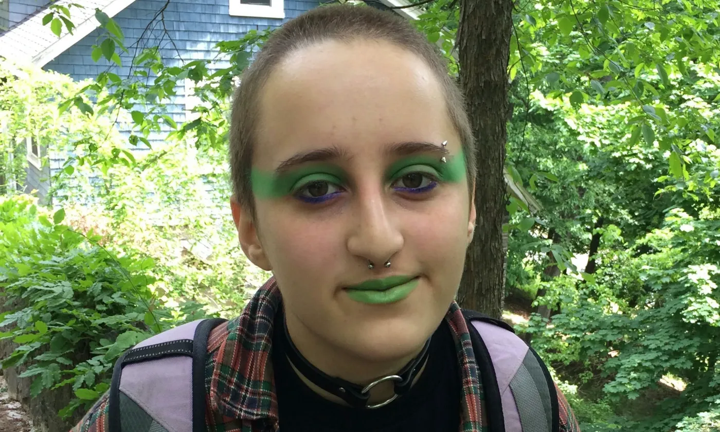 Neta in green makeup, portrait in front of trees